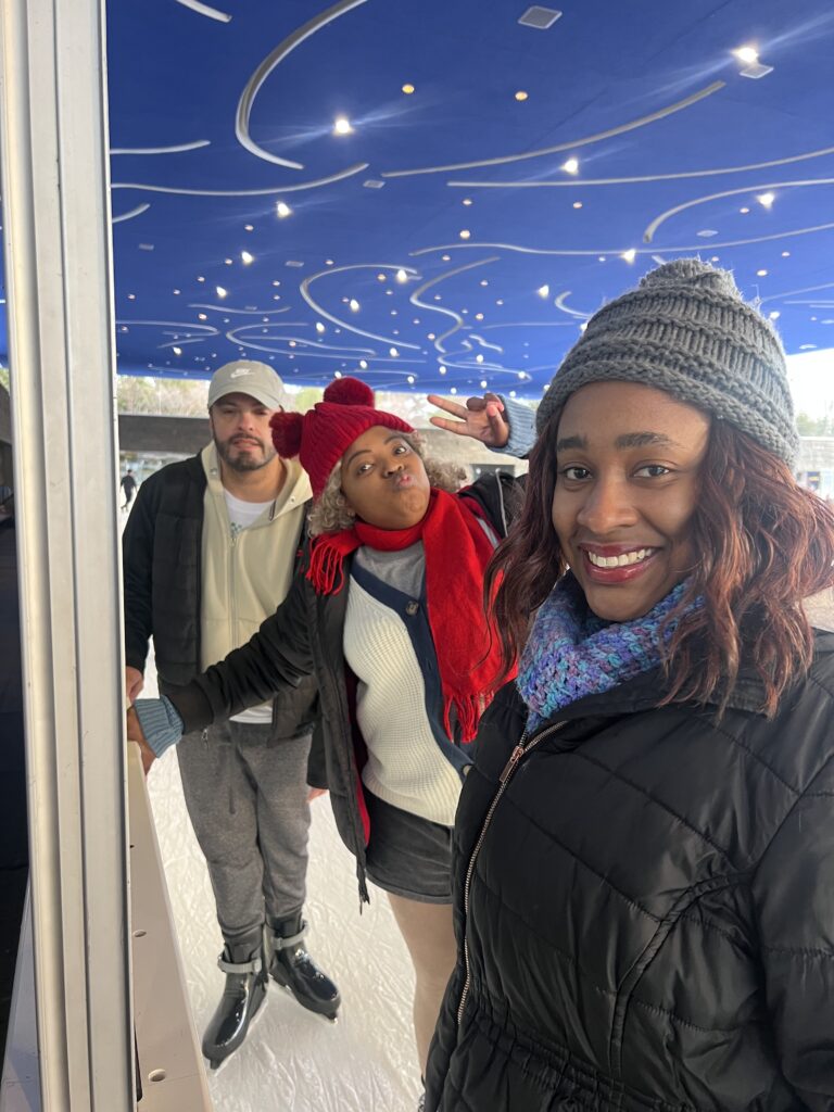 Young adults in winter hats smiling together for a group selfie
