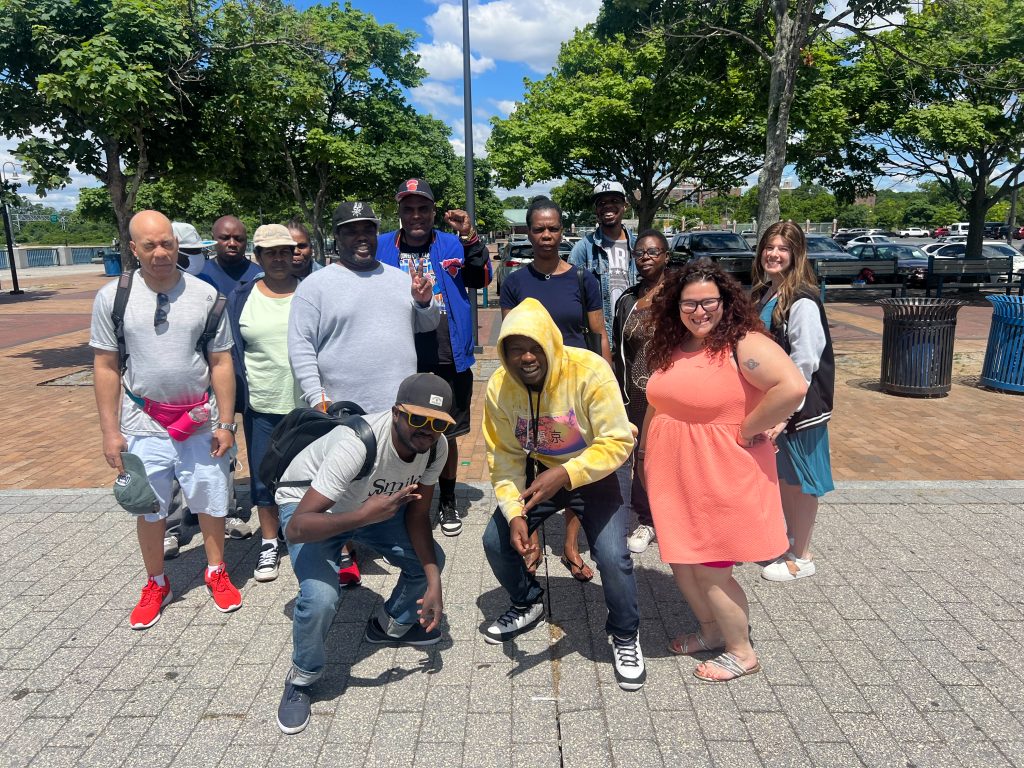 Group of BCS participants and staff smiling together outdoors, part of BCS mental health support in Brooklyn